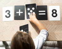A child working out 3 plus 5 with the Numbers cards and their dot cards