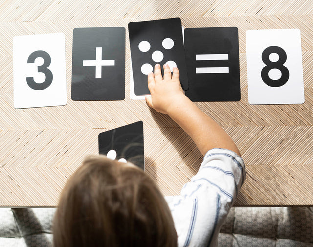 A child working out 3 plus 5 with the Numbers cards and their dot cards